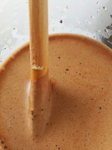 Coffee Grounds Blooming in a French Press Wooden stick stirring in coffee during blooming in a French press beaker
